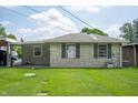 Well-maintained backyard with lush green grass, exterior brick, and mature trees at 924 N Devon Ave, Indianapolis, IN 46219