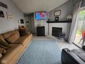 Inviting living room featuring plush seating, a cozy fireplace, and a mounted TV for comfortable relaxation at 9507 Colony Pointe E Dr, Indianapolis, IN 46250