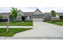 Beautiful single-story home with a long concrete driveway and a well-maintained front lawn at 9741 Haughton Ln, McCordsville, IN 46055