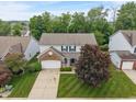Aerial view of a two-story home featuring manicured lawn, brick accents, and a paved driveway at 9756 Brook Meadow Dr, McCordsville, IN 46055