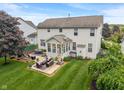Aerial view of a home's backyard featuring a patio with outdoor seating and a lush lawn at 9756 Brook Meadow Dr, McCordsville, IN 46055