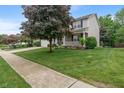 Exterior side view of a home with a well-manicured lawn and mature shade tree in a quiet neighborhood at 9756 Brook Meadow Dr, McCordsville, IN 46055