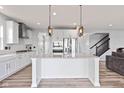 Modern kitchen with white cabinetry, stainless steel appliances, an island, and stylish pendant lighting at 9917 Gallop Ln, Fishers, IN 46040