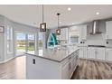 Kitchen with white cabinets and an island, opening up to a view of the backyard and patio at 9917 Gallop Ln, Fishers, IN 46040