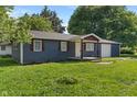 Well-kept home featuring blue siding, a covered porch, and an attached garage at 1002 Collier St, Indianapolis, IN 46241