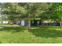 Spacious yard showcasing the home's exterior, complete with lush greenery and mature trees at 1002 Collier St, Indianapolis, IN 46241