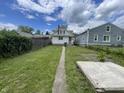 Large backyard with a sidewalk leading to the house and a mix of grass and other greenery at 1021 W 37Th St, Indianapolis, IN 46208