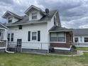 Side view of a two-story home with white siding, black shutters, and a well-maintained lawn at 1021 W 37Th St, Indianapolis, IN 46208