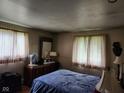Bedroom featuring two windows with curtains, and a bed with blue comforter, and wooden dresser at 10307 Orchard Park S Dr, Carmel, IN 46280