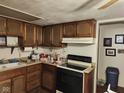Classic kitchen with brown cabinets and a black stove, ready for your updates and personal touch at 10307 Orchard Park S Dr, Carmel, IN 46280
