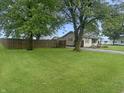 A spacious, green front lawn with a house and fence in the background at 108 N A St, Elwood, IN 46036