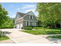 Exterior view highlighting the home's architecture, attached garage, well-maintained lawn, and expansive driveway at 11061 Mast Ct, Fishers, IN 46040