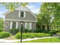 Charming front exterior featuring stone accents, manicured landscaping and a welcoming entrance, framed by lush trees at 11061 Mast Ct, Fishers, IN 46040