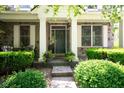 Inviting front porch area with stone steps, columns, and a beautifully decorated front door with surrounding greenery at 11061 Mast Ct, Fishers, IN 46040