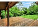 A wooden back porch overlooks a large, lush yard with mature trees providing privacy and shade at 11469 Woodview Ct, Fishers, IN 46038