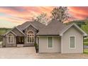Charming home with a stone facade and a three-car garage set against a vibrant sunset backdrop at 11911 W Grandview Dr, Columbus, IN 47201