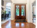 Elegant foyer featuring hardwood floors, a decorative front door, and views into the dining and living areas at 11911 W Grandview Dr, Columbus, IN 47201