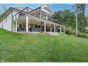 Expansive two-story deck with outdoor seating, ceiling fans, and string lights offers stunning outdoor living space at 11911 W Grandview Dr, Columbus, IN 47201