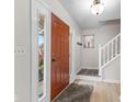 Entryway with hardwood floors, white walls, staircase, and an orange front door with sidelights at 12524 Trophy Dr, Fishers, IN 46038