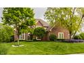 Beautiful brick home with mature trees and lush green lawn, offering great curb appeal at 12539 Pebblepointe Pass, Carmel, IN 46033