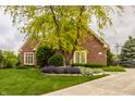 Attractive brick home showcasing vibrant landscaping and a well-maintained front yard at 12539 Pebblepointe Pass, Carmel, IN 46033