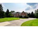 Beautiful brick home boasting lush landscaping, a curved driveway, and a charming architectural design at 12854 Northants Cir, Carmel, IN 46032