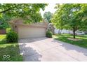 Charming brick home with a well-manicured lawn, mature trees, and an attached two-car garage at 13911 Naples Dr, Fishers, IN 46038