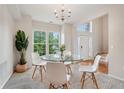 Bright dining room with a glass table, modern chairs, and large windows at 14036 Rayners Ln, Fishers, IN 46037