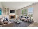 Spacious living room with a fireplace, built-in shelves, and comfortable seating at 14036 Rayners Ln, Fishers, IN 46037