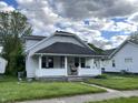 Charming home exterior with covered front porch and well maintained lawn at 207 E Plum St, Anderson, IN 46012