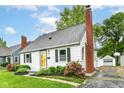 Charming single-story home with a brick chimney, black shutters and manicured landscaping at 2526 Dell Zell Dr, Indianapolis, IN 46220