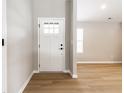 Light-filled foyer with wood-look floors and a white front door and neutral walls at 321 Virginia St, Fortville, IN 46040