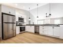 Bright, modern kitchen with stainless steel appliances, white cabinets, and black countertops at 321 Virginia St, Fortville, IN 46040