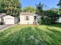 Quaint single-story home with a well-manicured front lawn and a detached one car garage at 3321 Sycamore Dr, Columbus, IN 47203
