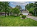 Charming home boasts a well-manicured lawn, inviting porch, and an attached two-car garage at 4013 Hillendale Dr, Greenwood, IN 46142