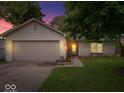 Charming single-story home with a brick facade, attached garage, and a well-maintained front yard at dusk at 4016 Dogwood Ln, Franklin, IN 46131
