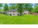 Expansive backyard featuring a well-manicured lawn, small deck, and mature trees at 426 Tipton Ln, Columbus, IN 47201