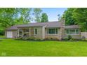 Attractive single-story home with stone facade, lush lawn, and mature landscaping at 426 Tipton Ln, Columbus, IN 47201