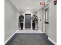 Well-lit hallway with neutral colors, potted plants, and exit sign at 435 Virginia Ave # 108, Indianapolis, IN 46203