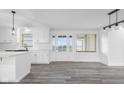 Bright kitchen features white cabinets, gray wood floors, and a view of the yard through the french doors at 4605 S 150 W, Columbus, IN 47201