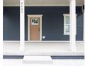 Close-up view of the front porch featuring white pillars and a modern front door at 4625 W Naomi St, Indianapolis, IN 46241