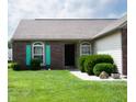 A well-kept single-story home with brick and siding, featuring vibrant turquoise shutters at 540 Cahill Ln, Indianapolis, IN 46214