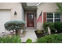 Inviting front entry with brick facade, American flag, and a beautiful garden, creating a warm, welcoming appeal at 5576 W Glenview Dr, McCordsville, IN 46055