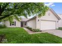 Charming single-story home featuring a two-car garage, well-kept lawn, and tasteful landscaping under blue sky at 6011 Twyckenham Dr, Indianapolis, IN 46236