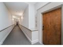 Long, well-lit hallway with gray carpet and white walls leads to an apartment door numbered 108 at 611 N Park Ave # 108, Indianapolis, IN 46204