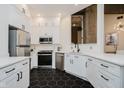 Modern kitchen with white cabinetry, stainless steel appliances, and a black hexagonal tile floor at 611 N Park Ave # 108, Indianapolis, IN 46204