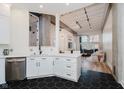 Open concept kitchen showcasing white cabinetry, stainless appliances, and view to the living room at 611 N Park Ave # 108, Indianapolis, IN 46204