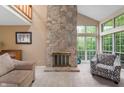 Comfortable living room boasts a stone fireplace, large windows, and vaulted ceilings at 6263 Behner Way, Indianapolis, IN 46250