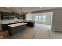 Bright eat-in kitchen boasts stylish green cabinets and ample natural light from surrounding windows at 6450 Stone Side Dr, Plainfield, IN 46168