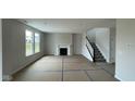 An open living room showcasing a fireplace, staircase, and plenty of natural light at 6450 Stone Side Dr, Plainfield, IN 46168